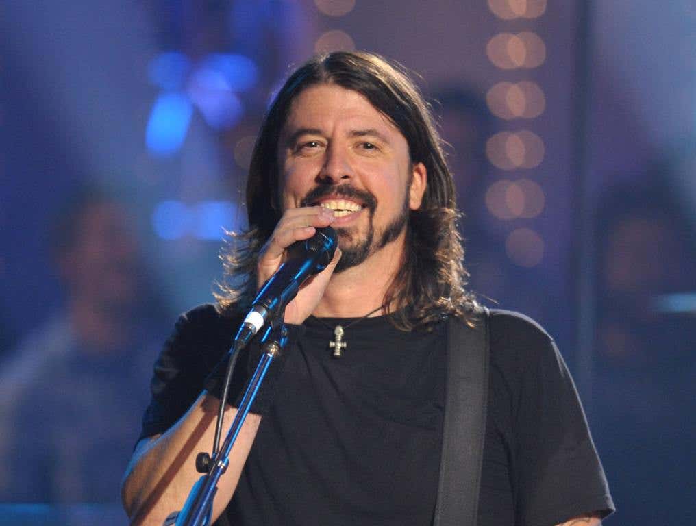 Dave Grohl standing in front of a microphone.