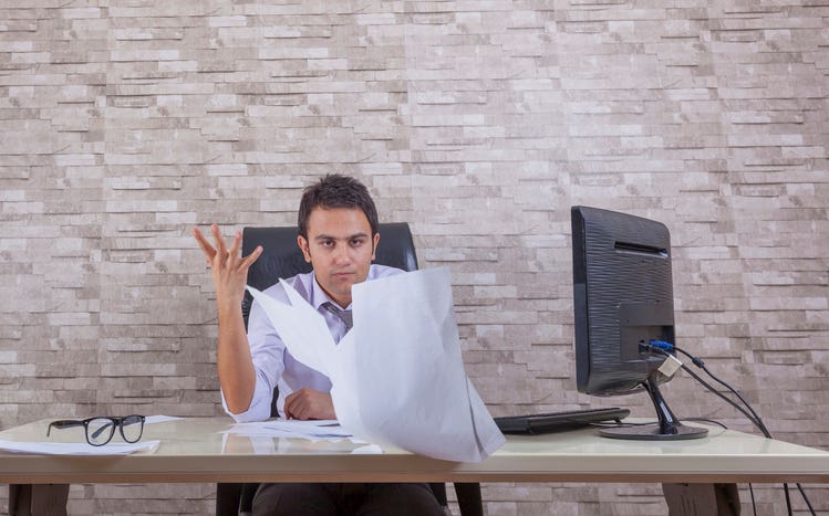 guy at a desk looking frustrated